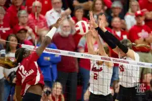 Nebraska Cornhusker Bergen Reilly (2) and Andi Jackson (15) block a shot from Wisconsin Badgers Temi Thomas-Ailara (12) in the first set during a college volleyball match on Saturday, October 21, 2023, in Lincoln, Nebraska. Photo by John S. Peterson.