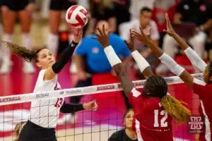 Nebraska Cornhusker Merritt Beason (13) tips the ball against Wisconsin Badgers outside hitter Temi Thomas-Ailara (12) in the first set during a college volleyball match on Saturday, October 21, 2023, in Lincoln, Nebraska. Photo by John S. Peterson.