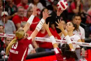 Nebraska Cornhusker Merritt Beason (13) spikes the ball against Wisconsin Badgers Sarah Franklin (13) and CC Crawford (9) in the second set during a college volleyball match on Saturday, October 21, 2023, in Lincoln, Nebraska. Photo by John S. Peterson.