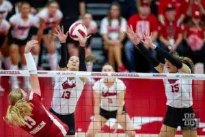 Nebraska Cornhusker Merritt Beason (13) and Nebraska Cornhusker Andi Jackson (15) jump to block Wisconsin Badgers outside hitter Sarah Franklin (13) in the second set during a college volleyball match on Saturday, October 21, 2023, in Lincoln, Nebraska. Photo by John S. Peterson.