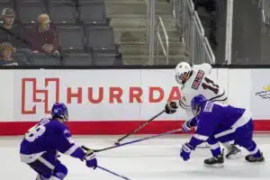 Omaha Mavericks forward Nolan Sullivan (11) skates with the puck against Niagara Purple Eagles forward Glebs Prohorenkovs (4) in the third period during a college hockey match on Friday, October 13, 2023, in Omaha, Nebraska. Photo by John S. Peterson.