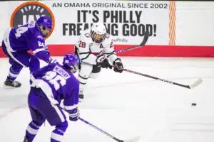 Omaha Mavericks forward Jack Randl (28) keeps the puck away from Niagara Purple Eagles defenseman Josef Mysak (24) in the third period during a college hockey match on Friday, October 13, 2023, in Omaha, Nebraska. Photo by John S. Peterson.