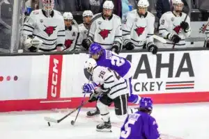 Omaha Mavericks forward Brock Bremer (26) moves the puck down the ice against Niagara Purple Eagles defenseman David Posma (29) during a college hockey match on Friday, October 13, 2023, in Omaha, Nebraska. Photo by John S. Peterson.
