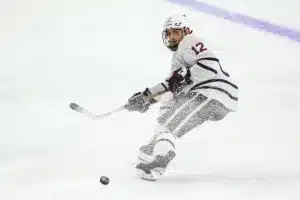 Omaha Mavericks defenseman Nolan Krenzen (12) passes the puck against the Niagara Purple Eagles in the third period during a college hockey match on Friday, October 13, 2023, in Omaha, Nebraska. Photo by John S. Peterson.