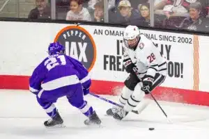 Omaha Mavericks forward Jack Randl (28) battles for the puck against Niagara Purple Eagles forward Shane Ott (21) in the first period during a college hockey match on Friday, October 13, 2023, in Omaha, Nebraska. Photo by John S. Peterson.
