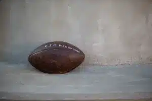 Football left at the statue of Dick Butkus after his death the day before the game between Nebraska and Illinois during a college football game in Lincoln, Nebraska, Friday, October 6, 2023. Photo by John Peterson.