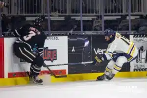 Omaha Maverick defenseman Kirby Proctor (3) fights for the puck against Augustana Viking forward Luke Mobley (15) in the third period during the hockey match on Saturday, November 25, 2023, in Sioux Falls, SD. Photo by John S. Peterson.