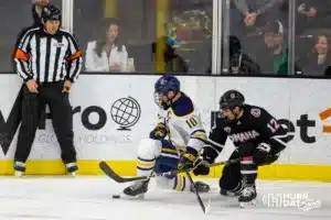 Augustana Viking forward Arnaud Vachon (10) and Omaha Maverick defenseman Nolan Krenzen (12) fight for the puck in the second period during the hockey match on Saturday, November 25, 2023, in Sioux Falls, SD. Photo by John S. Peterson.
