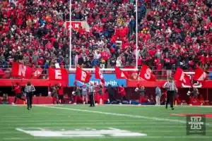 Nebraska Cornhusker cheerleaders run the flags in the endzone after a touchdown against the Iowa Hawkeyes during the football game on Thursday, November 24, 2023, in Lincoln, Neb. Photo by John S. Peterson.