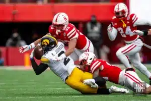 Nebraska Cornhusker linebacker Javin Wright (33) and linebacker Jimari Butler (10) tackles Iowa Hawkeye running back Kaleb Johnson (2) in the first quarter during the football game on Thursday, November 24, 2023, in Lincoln, Neb. Photo by John S. Peterson.