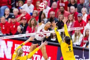 Nebraska Cornhusker Harper Murray (27) spikes the ball against Michigan Wolverine Jacque Boney (17) and Morgan Burke (7) in the third set during the volleyball match on Friday, November 17, 2023, in Lincoln, Nebraska. Photo by John S. Peterson.