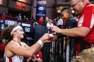 Nebraska Cornhusker forward Josiah Allick (53) signs an autograph for a young fan after the win over the Rider Broncs during the basketball game on Monday, November 13, 2023, in Lincoln, Nebraska. Photo by John S. Peterson.