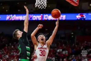 Nebraska Cornhusker guard Keisei Tominaga (30) makes a layup against North Dakota Fighting Hawk forward Brady Danielson (15) in the second half during a college basketball game Wednesday, December 20, 2023, in Lincoln, Nebraska. Photo by John S. Peterson.