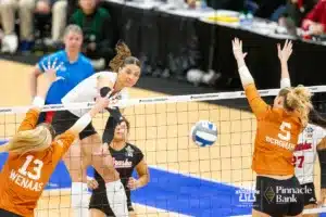 Nebraska Cornhusker outside hitter Merritt Beason (13) spikes the ball between Texas Longhorn outside hitter Jenna Wenaas (13) and middle blocker Bella Bergmark (5) in the first set during the NCAA Finals on Sunday, December 17, 2023, in Tampa, Florida. Photo by John S. Peterson.
