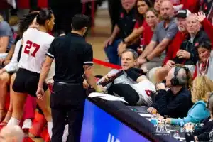 Nebraska Cornhusker Laney Choboy (6) flies into coach John Cook going after the ball in the third set against the Georgia Tech Yellow Jackets during the third round in the NCAA Volleyball Championship match Thursday, December 7, 2023, Lincoln, Neb. Photo by John S. Peterson.