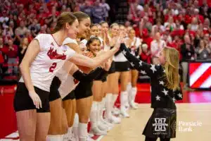 Nebraska Cornhusker Bergen Reilly (2) gives Ava Bonifas a high five after she sang the National Anthem before the match against the Missouri Tigers during the second round of the NCAA volleyball championships on Saturday, December 2, 2023, in Lincoln, Neb. Photo by John S. Peterson.