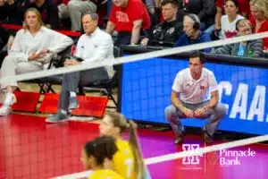 Nebraska Cornhusker assistant coach Jaylen Reyes watches the action on the court against the Long Island Sharks in the third set during the first round of the NCAA volleyball championships on Friday, December 1, 2023, in Lincoln, Neb. Photo by John S. Peterson.