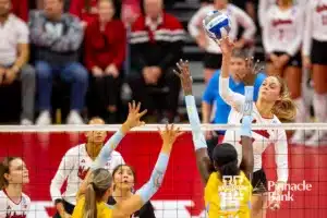 Nebraska Cornhusker Ally Batenhorst (14) spikes the ball against Long Island Shark Rumur Rouille (7) and Celine Mukura (15) in the first set during the first round of the NCAA volleyball championships on Friday, December 1, 2023, in Lincoln, Neb. Photo by John S. Peterson.