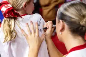 Nebraska Cornhusker guard Callin Hake (14) signs an autograph for a young fan after the win against the Illinois Fighting Illini during a college basketball game on Thursday, January 11, 2024, in Lincoln, Nebraska. Photo by John S. Peterson.