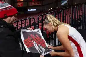 Australian Cornhusker guard Jaz Shelley (1) signs a poster for Australia Night after the win against the Illinois Fighting Illini during a college basketball game on Thursday, January 11, 2024, in Lincoln, Nebraska. Photo by John S. Peterson.
