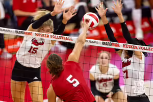 Nebraska Cornhusker Rebekah Allick (5) spikes the ball between Andi Jackson (15) and Harper Murray (27) during the Red/White Volleyball Game Saturday, August 24, 2024, in Lincoln, Nebraska. Photo John S. Peterson.