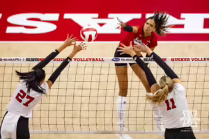 Nebraska Cornhusker Skylar Pierce (21) spikes the ball against Harper Murray (27) and Leyla Blackwell (11) during the Red/White Volleyball Game Saturday, August 24, 2024, in Lincoln, Nebraska. Photo John S. Peterson.