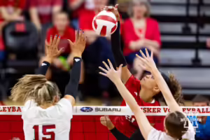 Nebraska Cornhusker Skylar Pierce (21) spikes the ball against Andi Jackson (15) and Bergen Reilly (2) during the Red/White Volleyball Game Saturday, August 24, 2024, in Lincoln, Nebraska. Photo John S. Peterson.