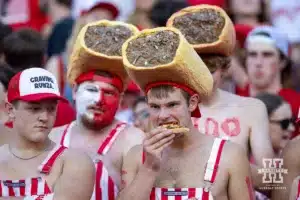 Nebraska Cornhusker fan eating a Valentino's pizza slice wearing a Runza hat before the game against the Illinois Fighting Illini during a college football game Firiday, September 20, 2024, in Lincoln, Nebraska. Photo by John S. Peterson.