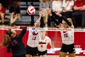 Nebraska Cornhusker Merritt Beason (13) and Andi Jackson defend against Stanford Cardinal Elia Rubin (13) spike in the third set during a college volleyball match Wednesday, September 18, 2024, in Lincoln, Nebraska. Photo by John S. Peterson.