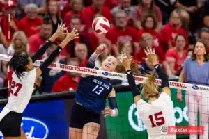 Creighton Bluejay defensive specialist Morgan Colangelo (13) spikes the ball between Nebraska Cornhusker outside hitter Harper Murray (27) and middle blocker Andi Jackson (15) in the third set during the college volleyball match Tuesday, September 10, 2024, in Lincoln, Nebraska. Photo John S. Peterson.