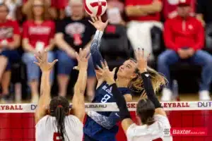 Creighton Bluejay outside hitter Ava Martin (8) spikes the ball against Nebraska Cornhusker middle blocker Rebekah Allick (5) and Nebraska Cornhusker outside hitter Merritt Beason (13) during the college volleyball match Tuesday, September 10, 2024, in Lincoln, Nebraska. Photo John S. Peterson.