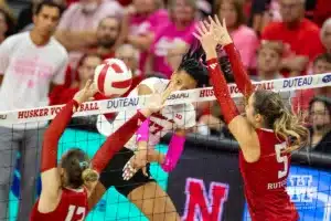 Nebraska Cornhusker Harper Murray (27) spikes the ball against Rutgers Scarlet Knight middle blocker Ece Emrullah (13) and Aly Borellis during a college volleyball match Saturday, October 12, 2024, in Lincoln, Nebraska. Photo by John S. Peterson.