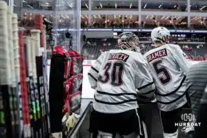 Omaha Mavericks Simon Latkoczy (30) and Joe Gramer (5) watching the action on the ice against the Wisconsin Badgers in a college hockey match Saturday, October 5, 2024 in Omaha, Nebraska. Photo by Kyle Byers.
