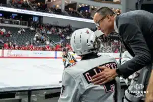 Omaha Maverick Griffin Ludtke (7) talking to a coach against the Wisconsin Badgers in a college hockey match Saturday, October 5, 2024 in Omaha, Nebraska. Photo by Kyle Byers.