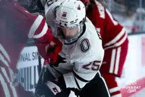 Omaha Maverick Cameron Mitchell (25) fights for a puck against the Wisconsin Badgers in a college hockey match Saturday, October 5, 2024 in Omaha, Nebraska. Photo by Kyle Byers.