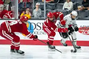 Omaha Maverick Zach Urdahl (6) fights for the puck against the Wisconsin Badgers in a college hockey match Saturday, October 5, 2024 in Omaha, Nebraska. Photo by Kyle Byers.
