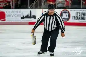 Ref picks up the fish after a goal in the hockey match between Omaha Mavericks and the Wisconsin Badgers Saturday, October 5, 2024 in Omaha, Nebraska. Photo by Kyle Byers.
