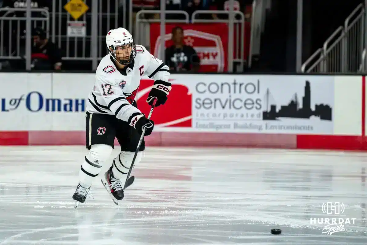 KJB20241005_HKY_OMA_WISC_0013 Omaha Maverick Nolan Krenzen (12) passes the puck against the Wisconsin Badgers in a college hockey match Saturday, October 5, 2024 in Omaha, Nebraska. Photo by Kyle Byers.