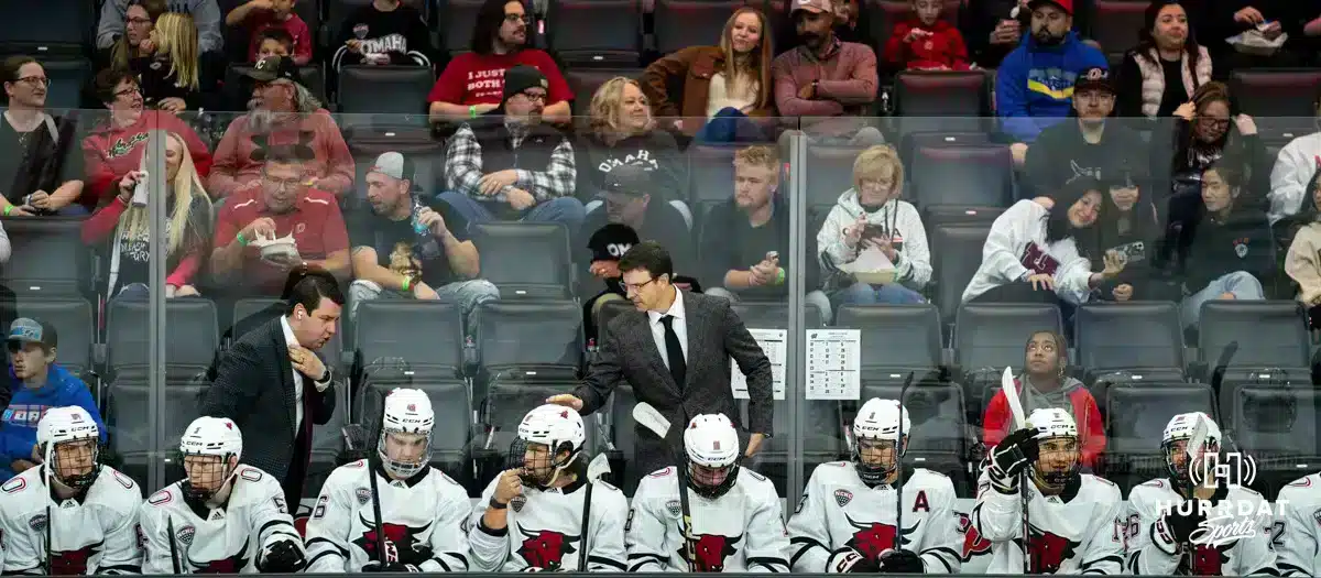Omaha head coach Mike Gabinet and Assistant Coach Bennett Hambrook talking to players on the bench against the Wisconsin Badgers in a college hockey match Saturday, October 5, 2024 in Omaha, Nebraska. Photo by Kyle Byers.