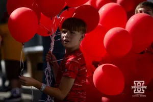 A boy handing out balloons for the balloon release against the Rutgers Scarlet Knights during a college football game Saturday, October 5, 2024, in Lincoln, Nebraska. Photo by John S. Peterson.