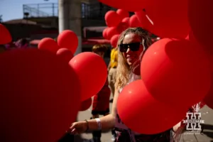 A lady handing out balloons for the balloon release against the Rutgers Scarlet Knights during a college football game Saturday, October 5, 2024, in Lincoln, Nebraska. Photo by John S. Peterson.