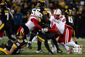 Nebraska Cornhuskers linebacker MJ Sherman (48) and defensive lineman Elijah Jeudy (16) tackles Iowa Hawkeyes running back Kamari Moulton (28) during a college football game Friday, November 29, 2024, in Iowa City, Iowa. Photo by John S. Peterson.