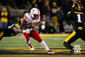Nebraska Cornhuskers running back Emmett Johnson (21) runs with the ball against Iowa Hawkeyes linebacker Jay Higgins (34) and defensive back Xavier Nwankpa (1) and linebacker Jay Higgins (34) in the second quarter during a college football game Friday, November 29, 2024, in Iowa City, Iowa. Photo by John S. Peterson.