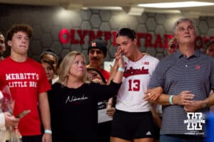 Nebraska Cornhusker Merritt Beason (13) standing with her parent for Senior Night after a college volleyball match against the Wisconsin Badgers Saturday, November 23, 2024 in Lincoln, Nebraska. Photo by John S. Peterson.