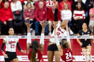 Nebraska Cornhusker outside hitter Taylor Landfair (12) spikes the ball against Wisconsin Badgers opposite Devyn Robinson (10) and setter Charlie Fuerbringer (24) in the second set during a college volleyball match Saturday, November 23, 2024 in Lincoln, Nebraska. Photo by John S. Peterson.