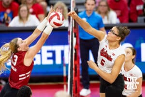 Nebraska Cornhusker middle blocker Rebekah Allick (5) spikes the ball around Wisconsin Badger outside hitter Sarah Franklin (13) in the second set during a college volleyball match Saturday, November 23, 2024 in Lincoln, Nebraska. Photo by John S. Peterson.