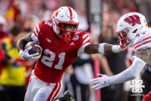 Nebraska Cornhusker running back Emmett Johnson (21) stiff arms a Wisconsin Badger during a college football game Saturday, November 23, 2024 in Lincoln, Nebraska. Photo by John S. Peterson.