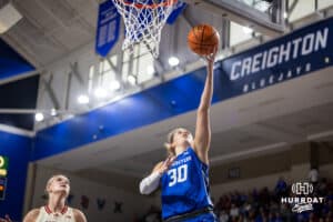 Creighton Bluejay guard Morgan Maly (30) makes a layup against Nebraska Cornhusker forward Jessica Petrie (12) in the first half during a women’s college basketball game Friday, November 22, 2024 in Omaha, Nebraska. Photo by John S. Peterson.