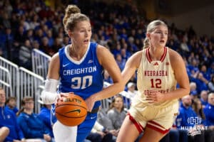 Creighton Bluejay guard Morgan Maly (30) drives to the basket against Nebraska Cornhusker forward Jessica Petrie (12) in the first half during a women’s college basketball game Friday, November 22, 2024 in Omaha, Nebraska. Photo by John S. Peterson.