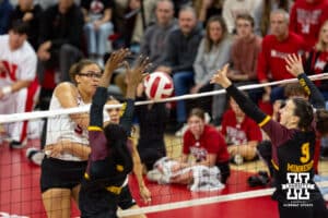 Nebraska Cornhusker Rebekah Allick (5) spikes the ball between Minnesota Golden Gopher Phoebe Awoleye (7) and Lydia Grote (9) in the third set during a college volleyball match Thursday, November 14, 2024, in Lincoln, Nebraska. Photo by John S. Peterson.